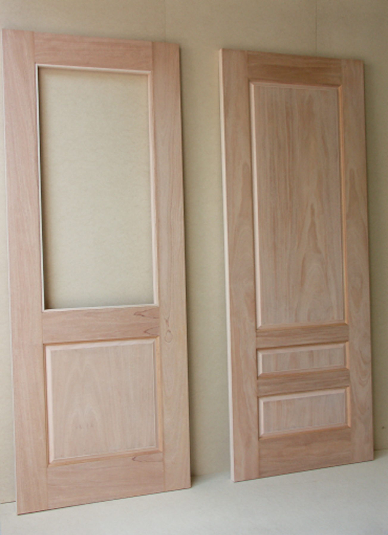Two cherry doors side by side, one with an upper lite and one with three panels