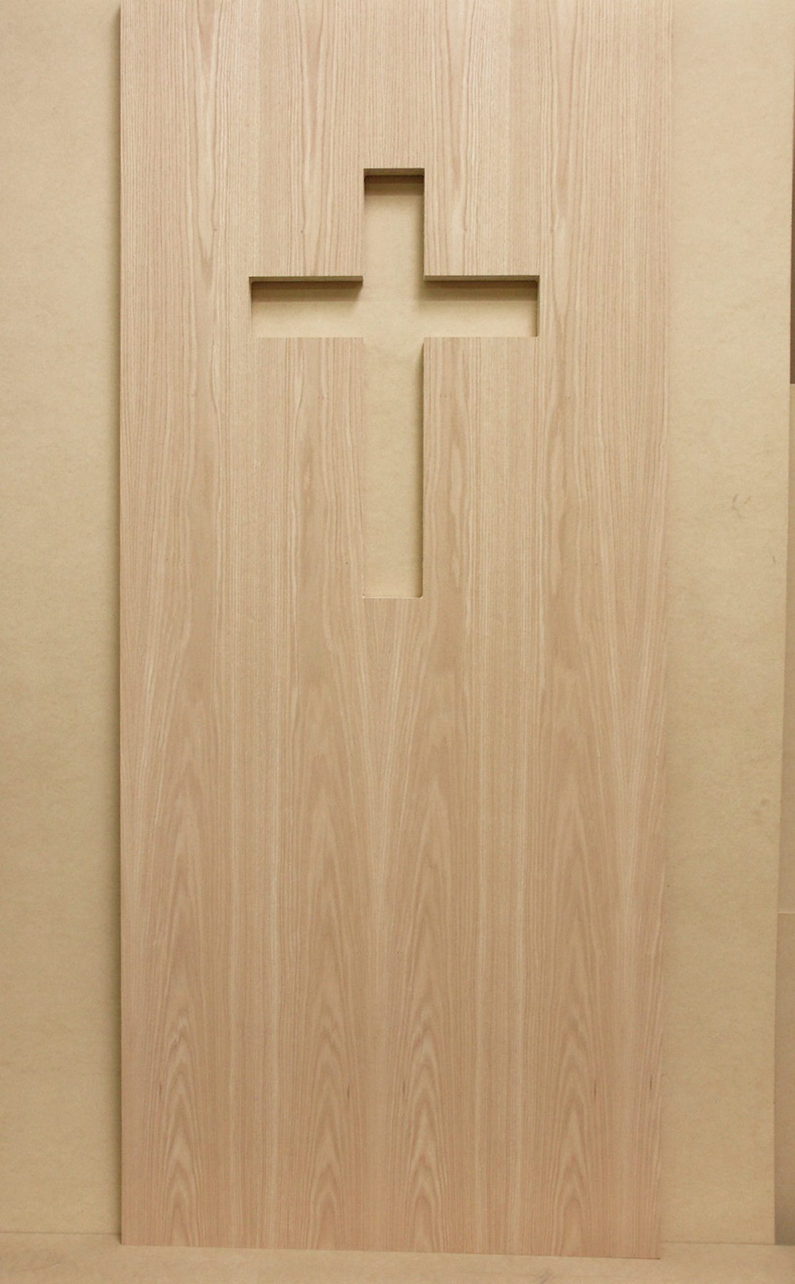 Plain sliced red oak door with a cross-shaped cutout