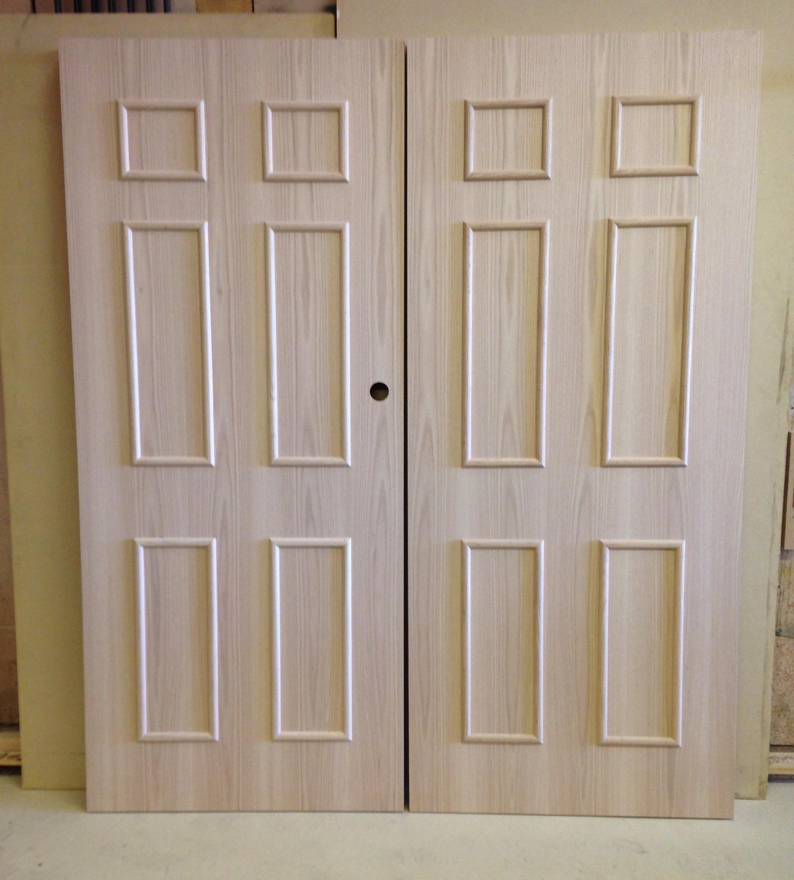 Pair of red oak doors with applied moulding forming six faux panels on each leaf