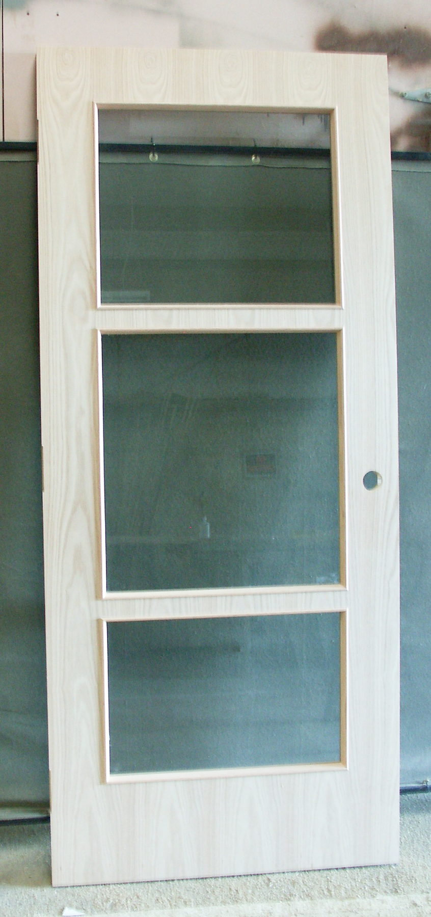 Light wood veneer door with three stacked glass lites