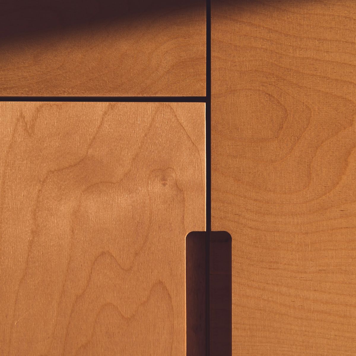 Close-up of maple veneer door panels meeting at a fine reveal